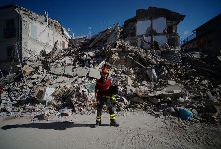 A fireman stands next to ruins in the central destroyed street of Amatrice in central Italy on August 25, 2016. Central Italy was struck by a powerful, 6.2-magnitude earthquake in the early hours of August 24, that shook central Italy and the death toll rose to 247 on August 25, as rescuers desperately searched for survivors in the rubble of devastated mountain villages. Photo Filipo Monteforte/AFP/Getty Images.