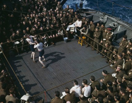 Robert Capa, [Soldados británicos viendo un combate de boxeo a bordo de un barco de Inglaterra a África del Norte], 1943. © Robert Capa/International Center of Photography/Magnum Photos   
