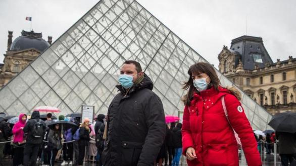 Two people wear a mask outside the Louvre this Monday (EFE)