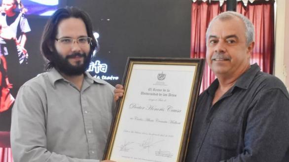 Carlos Alberto Cremata recibe de manos del Rector del ISA el diploma que lo acredita como Doctor Honoris Causa 