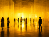 Visitantes recorren una instalación artística inmersiva dominada por tonos amarillos y cálidos que exploran la relación entre color, emoción y percepción visual