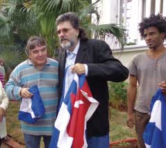 Abel Prieto Jimenez, an adviser to Cuban President Raul Castro, receives the Cuban flag from the hands of Julian Gonzalez, Minister of Culture, during the celebration of the birth of Jose Marti.