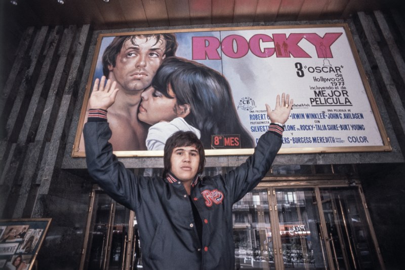 Carteles Cine en la Gran Vía. El boxeador Alfredo Evangelista posando ante el cartel del estreno de Rocky en Madrid. (12 de mayo de 1977)., colección particular de Benito Román.