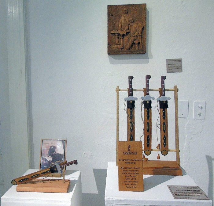 Machete de Máximo Gómez,  Montecristi; cuero vacuno, madera y fibra, e imagen  de José Martí y Máximo Gómez tallada  en madera
